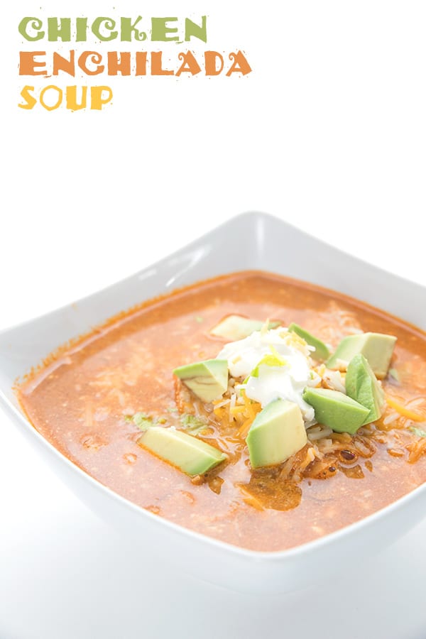 Easy Enchilada Soup in a bowl with cheese, sour cream and avocados