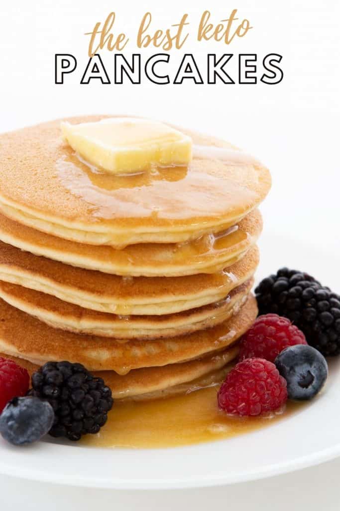 Titled image of a stack of keto pancakes on a white plate, with berries all around. 