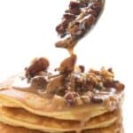 Titled image of a stack of keto pancakes with praline sauce being spooned overtop.