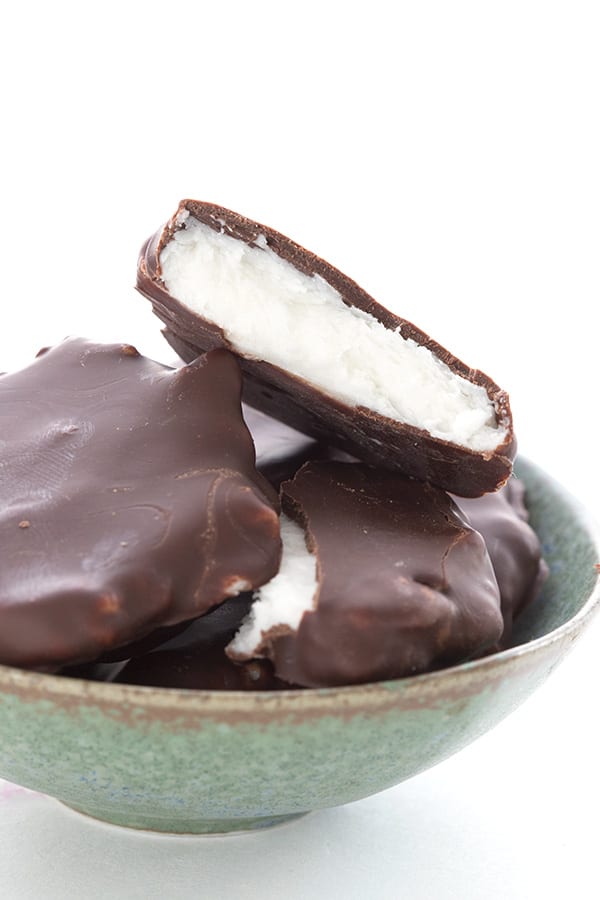 Sugar Free Keto Peppermint Patties in a bowl, with a bite taken out of one. 