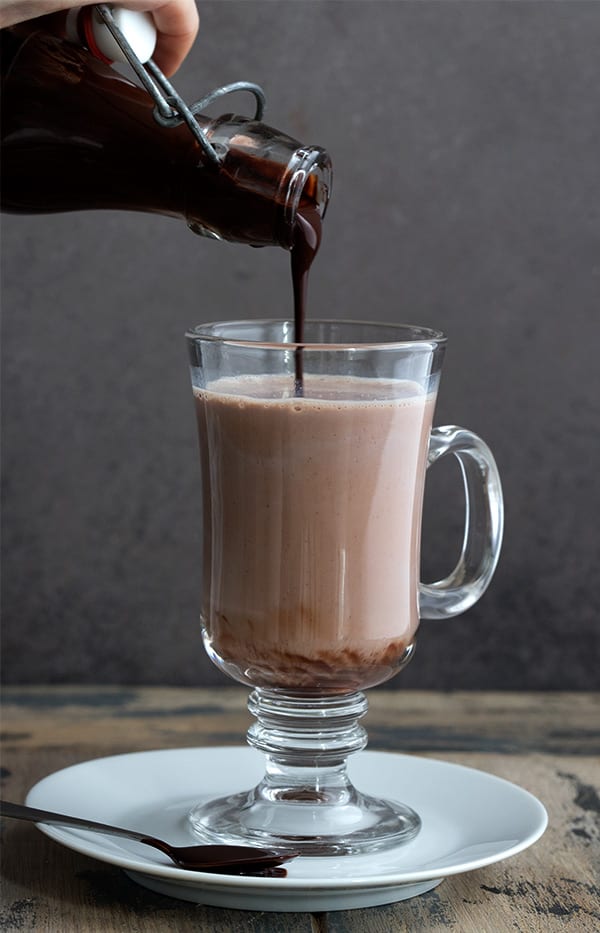 Sugar Free chocolate syrup being poured into a glass of milk