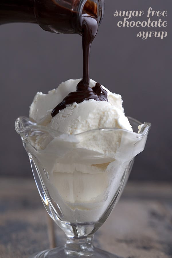 Sugar free chocolate syrup being poured over keto vanilla ice cream
