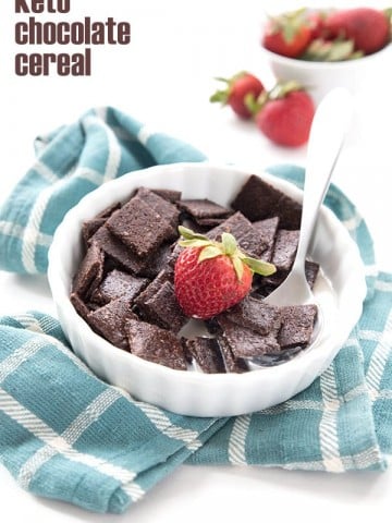 Keto Chocolate Cereal in a bowl with a strawberry and cream