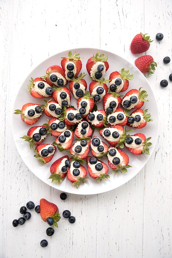 Top down photo of cheesecake stuffed strawberries with blueberries on top