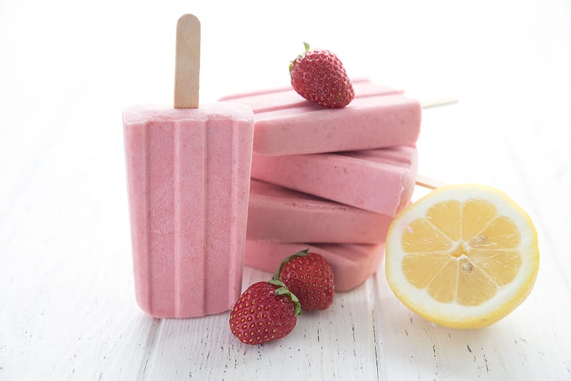 A stack of keto strawberry lemonade popsicles in a stack with one standing upright