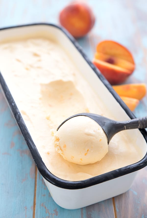 Low carb peach ice cream in a long rectangular container, with an ice cream scoop