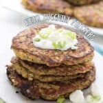 Titled image of Keto Zucchini Fritters in a stack on a white plate over a green napkin.