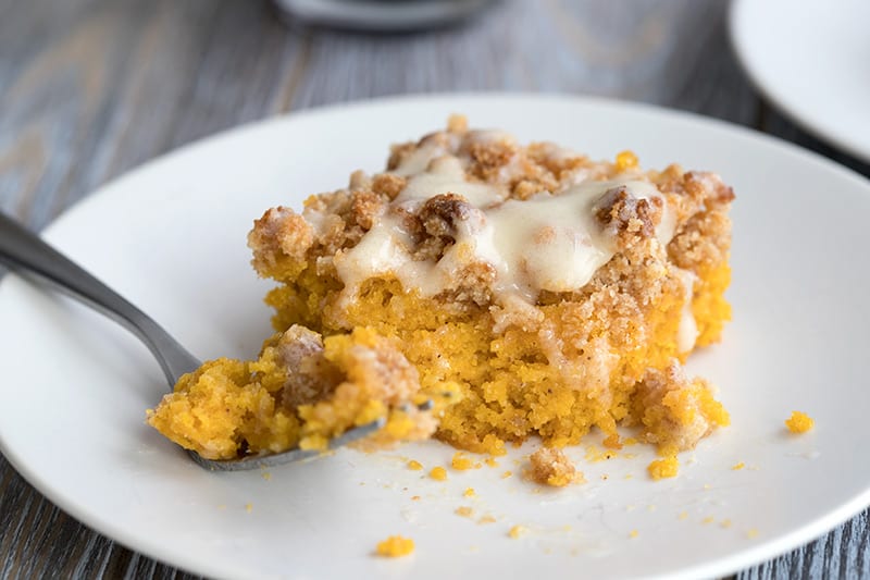 Close up shot of pumpkin coffee cake with a forkful taken out of it.