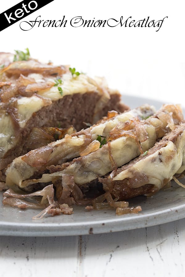 Close up shot of keto french onion meatloaf on a grey platter, smothered in cheese and caramelized onions.