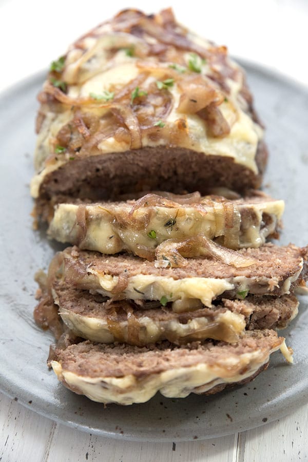 A close up shot of sliced keto meatloaf with caramelized onions and cheese. 