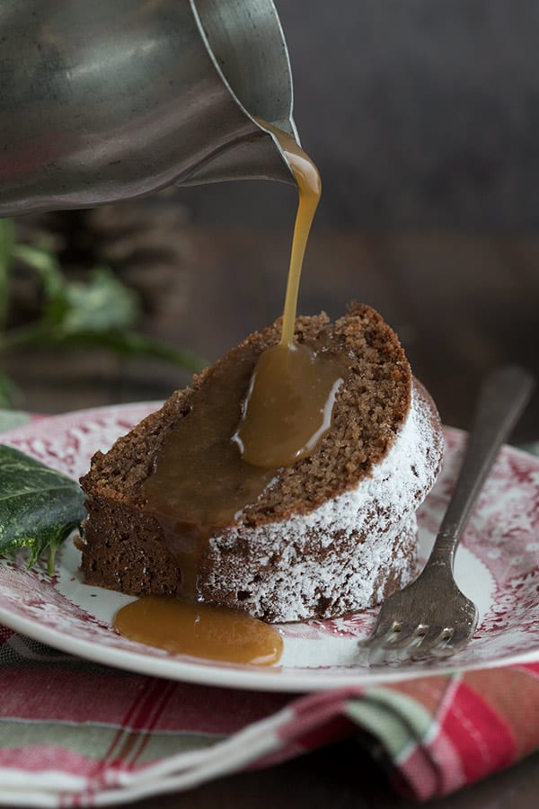 Drizzling sugar-free caramel sauce over a slice of keto gingerbread cake. 