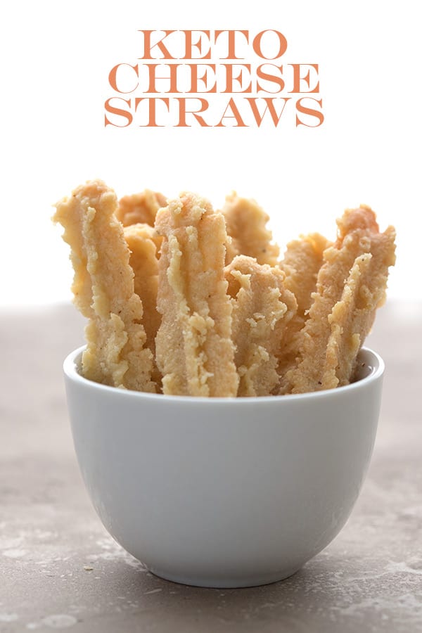 Keto cheese straws in a small white bowl on a brown table