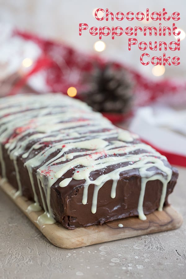 Keto chocolate peppermint pound cake on a wooden cutting board with holiday lights in behind. 
