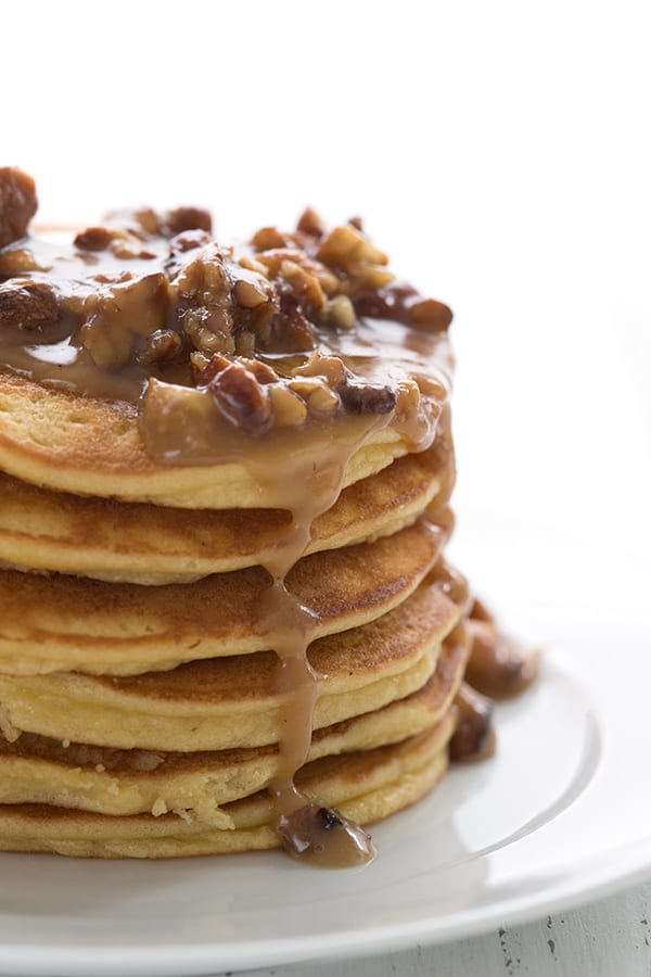 A stack of keto pancakes with praline sauce dripping down. 