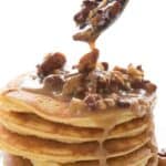 Titled Pinterest image of Keto Pecan Praline Sauce being drizzled off a spoon over keto pancakes.