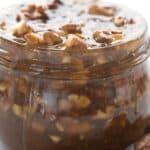 Titled image of a close up of keto praline sauce in a glass jar.