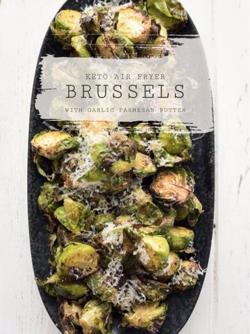 Top down photo of a black platter filled with air fryer Brussels sprouts on a white table.