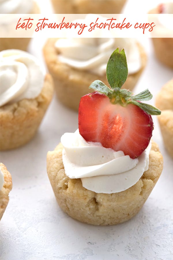 Title image of a keto strawberry shortcake cookie cup close up, with a slice of strawberry stuck in the top.