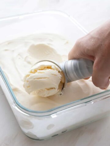 Scooping keto no churn ice cream out of the container.
