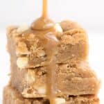 Titled image of caramel sauce being poured over a stack of Keto White Chocolate Blondies.