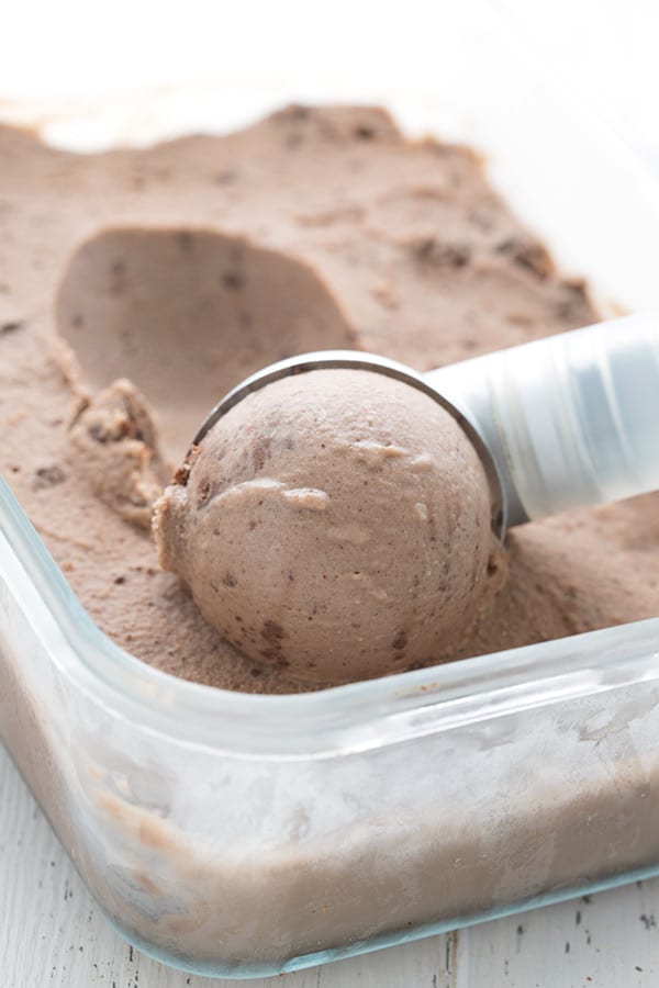 Close up shot of Keto Chocolate Hazelnut Ice Cream being scooped out of a glass container