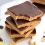 A stack of Keto Peanut Butter Bars with a bite taken out of the top one.