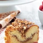 Titled image of a slice of Bakery-Style Keto Coffee Cake on a plate with fresh raspberries.