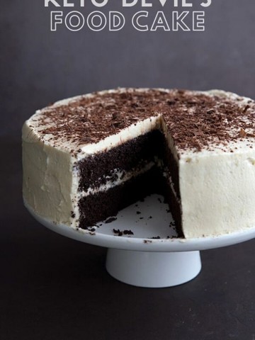 Titled image of keto devil's food cake on a white cake plate, with a slice cut out of it