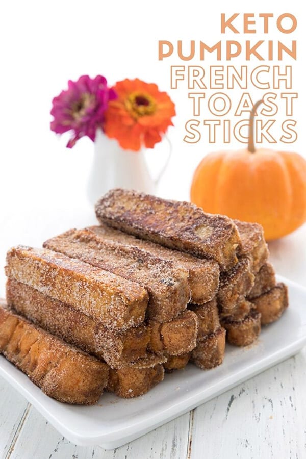 Titled image of keto french toast sticks on a white plate, with a pumpkin and some flowers in the background.