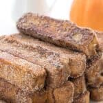 A stack of Keto Pumpkin French Toast Sticks on a white plate with the title across the top.