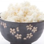 A black bowl with a flower pattern full of cauliflower rice
