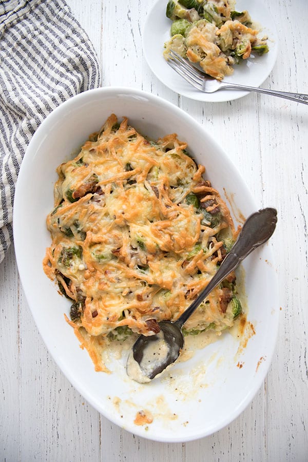 Top down photo of cheesy Brussels Sprouts Casserole in a white oval dish