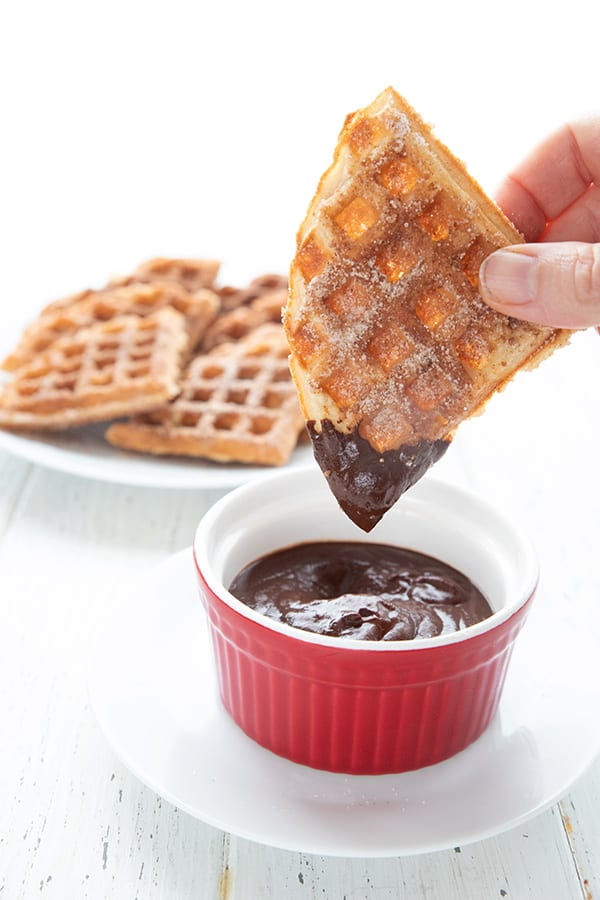Dipping a keto churro waffle in sugar-free chocolate sauce.