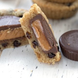 Close up shot of a keto cookie stuffed with peanut butter cups cut open to show the inside.