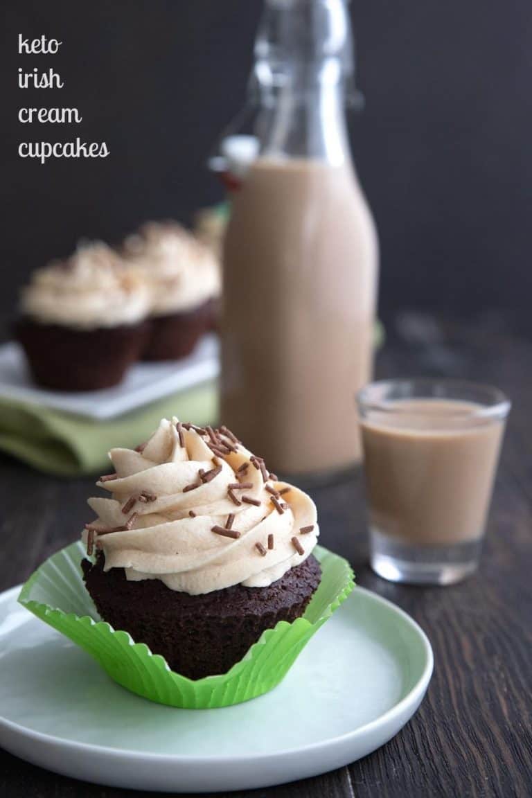 Titled image of a keto Irish Cream cupcake on a white plate, with the bottle of sugar free Irish Cream in behind.