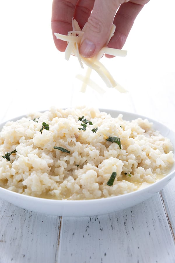 Sprinkling cheese over keto cauliflower risotto