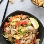 Top down image of a black bowl filled with keto pad thai on a gray table top.