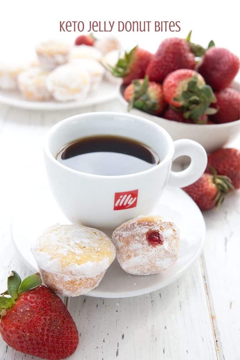 Titled image of keto jelly donut muffins on a saucer with a cup of coffee and strawberries in the background.