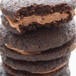 Titled image of a stack of Keto Chocolate Sandwich Cookies with a bite taken out of the top one.