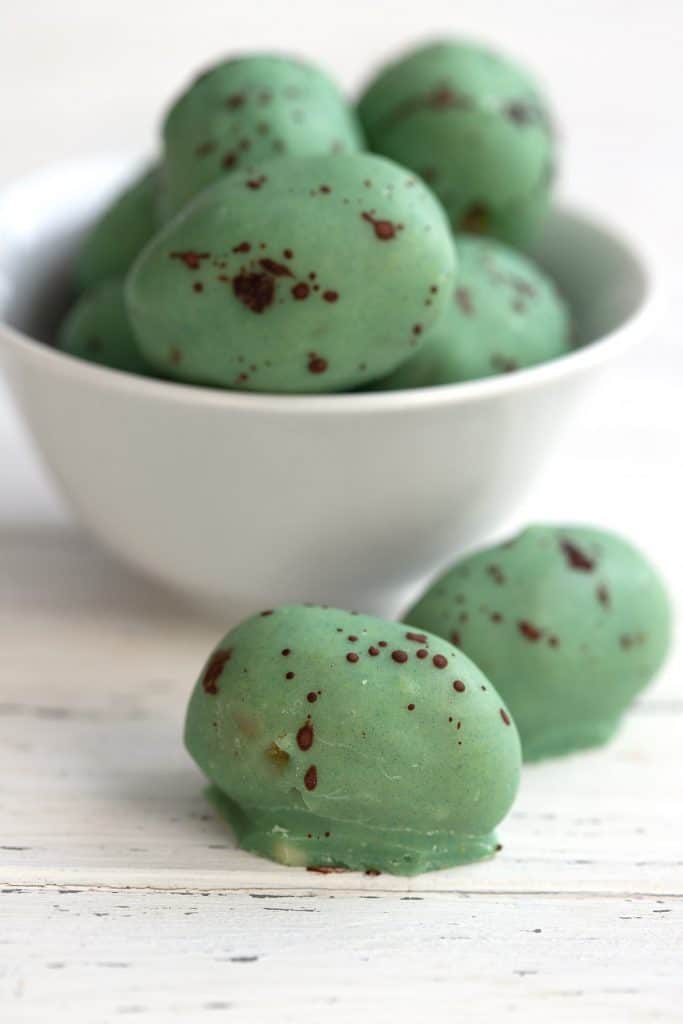 Mini keto Easter eggs made from sugar free marzipan and dipped in white chocolate that has been dyed green.