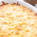 Titled Pinterest image for Ham and cheese cauliflower casserole in a white oval dish.