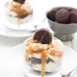 Two keto brownie parfaits in glass dessert dishes, with a bowl of mini brownie bites.