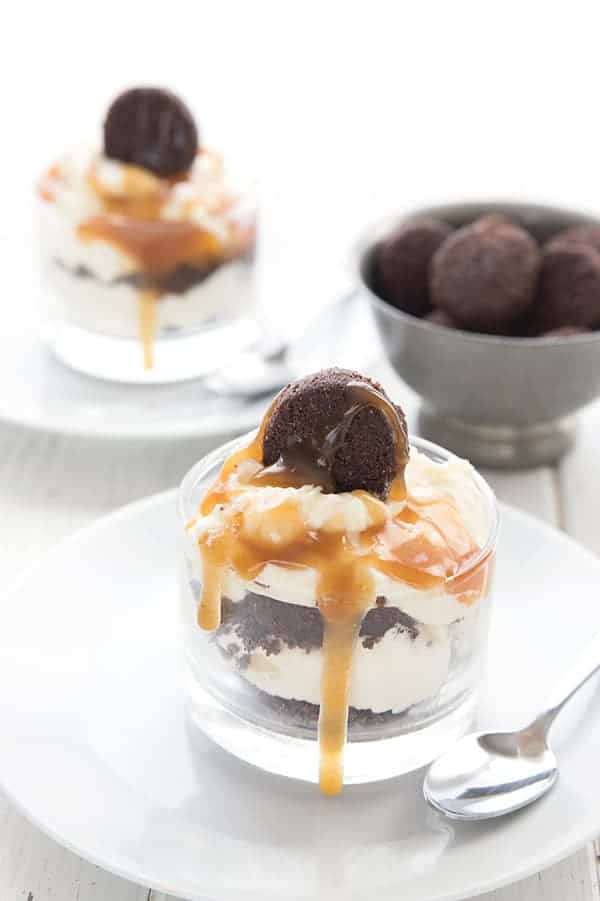 Two keto brownie parfaits in glass dessert dishes, with a bowl of mini brownie bites.