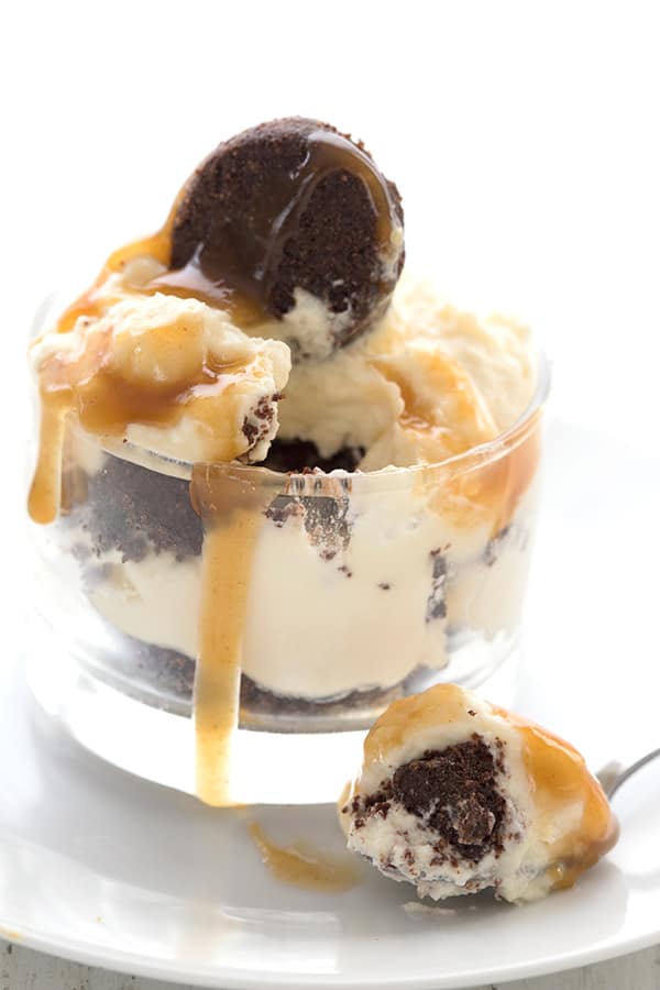 Close up shot of a keto parfait with brownies and caramel sauce, with one spoonful taken out of it.