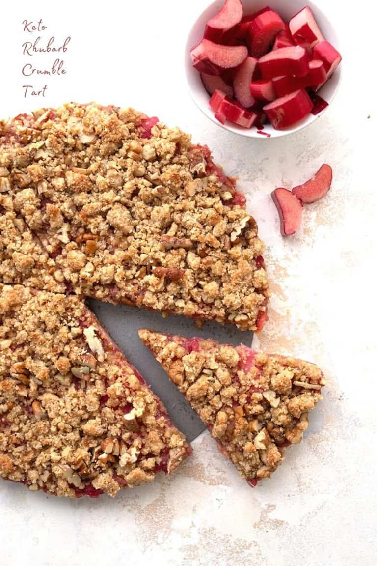 Titled image: top down photo of keto rhubarb tart on a white table, with a slice removed.