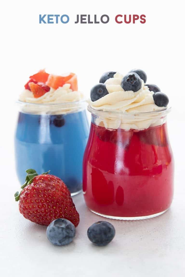 Titled image for keto sugar free jello in glass jars, one blue and one red, topped with whipped cream and berries.