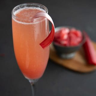 Close up shot of the top of a champagne flute filled with rhubarb fizz cocktail.