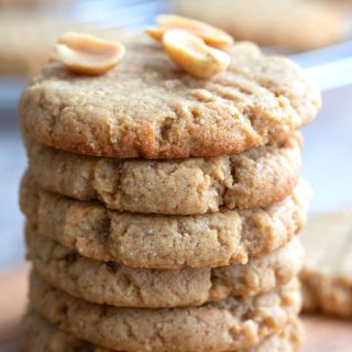 Close up shot of a stack of keto peanut butter cookies with peanuts on top.