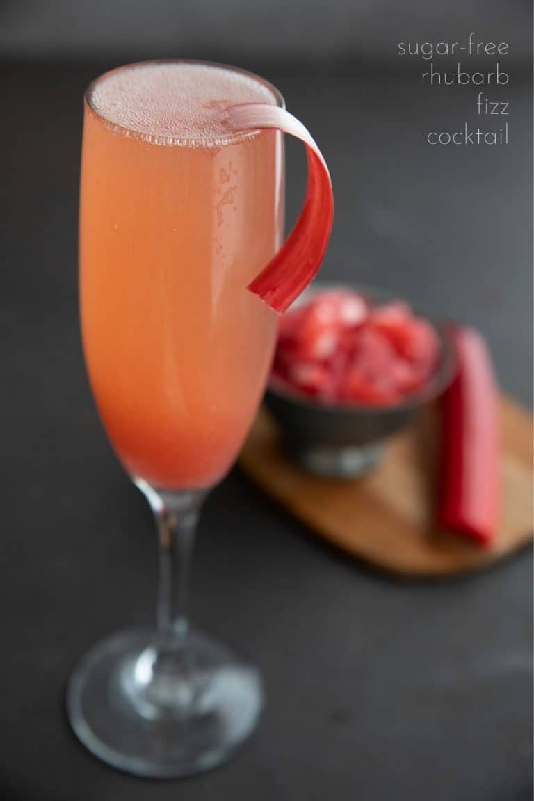 Titled image of a sugar free rhubarb cocktail in a champagne flute with a strip of peeled rhubarb as garnish.