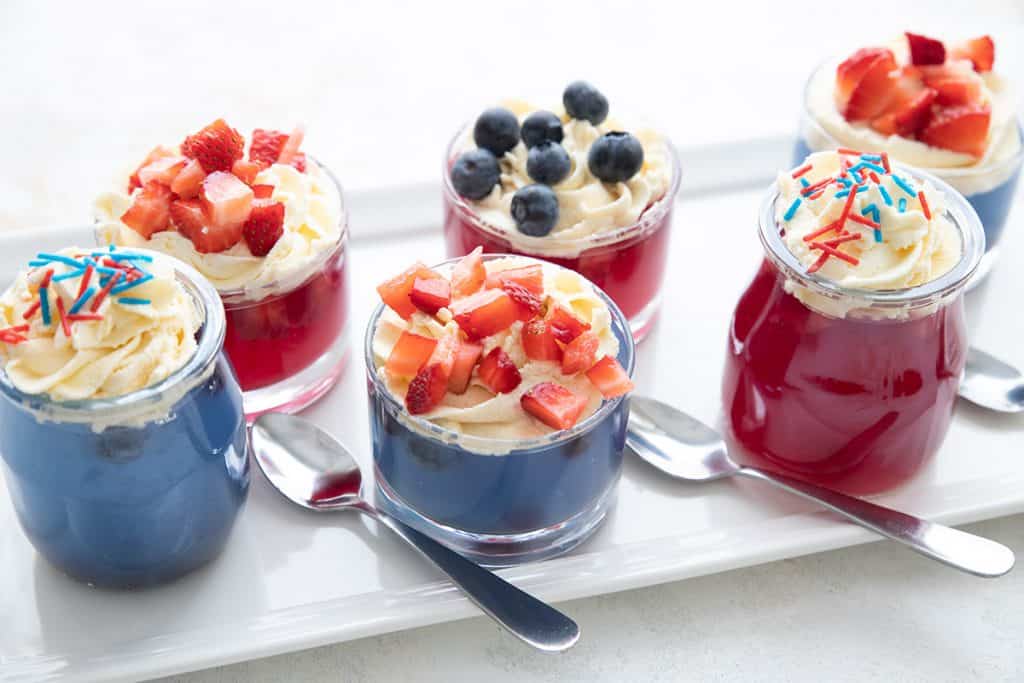 A white platter with jars of sugar free red white and blue jello cups.